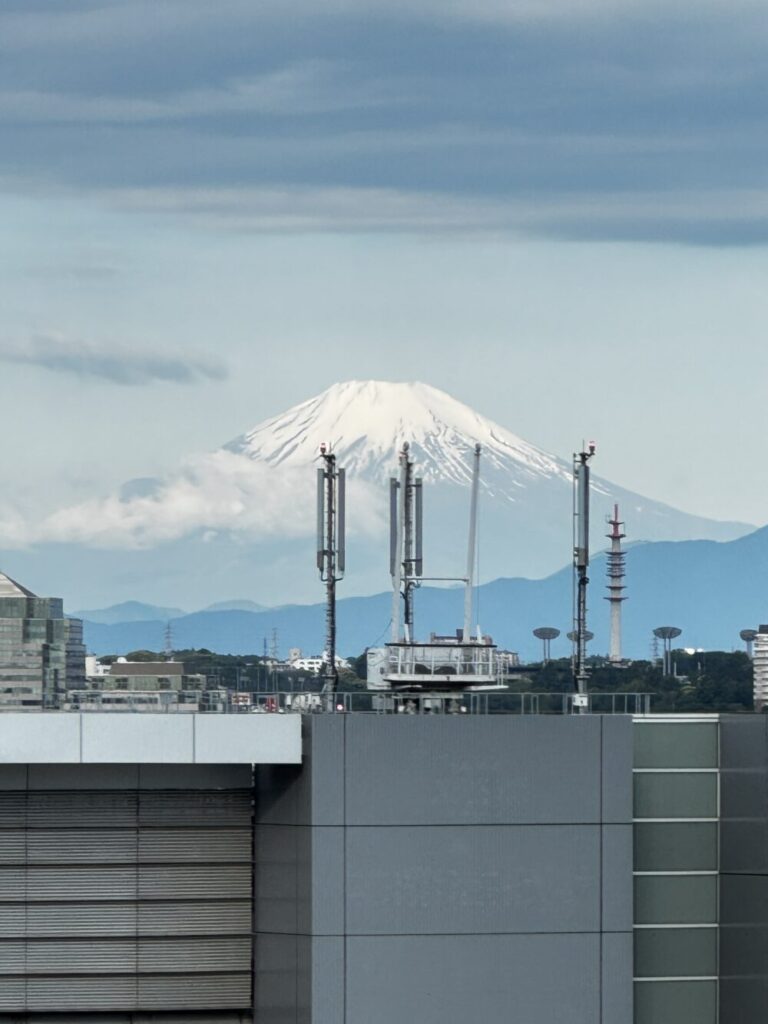 客室の窓から見た富士山。手前の建物のアンテナが重なっている