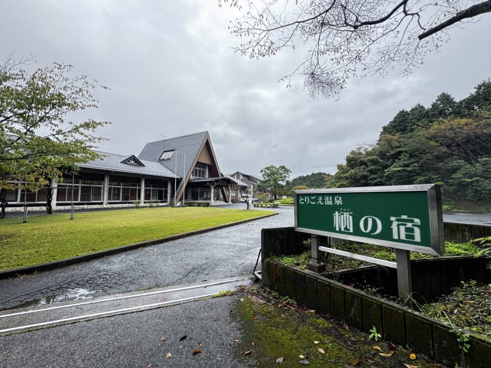 緑に囲まれたとりごえ温泉 栖の宿の建物と看板